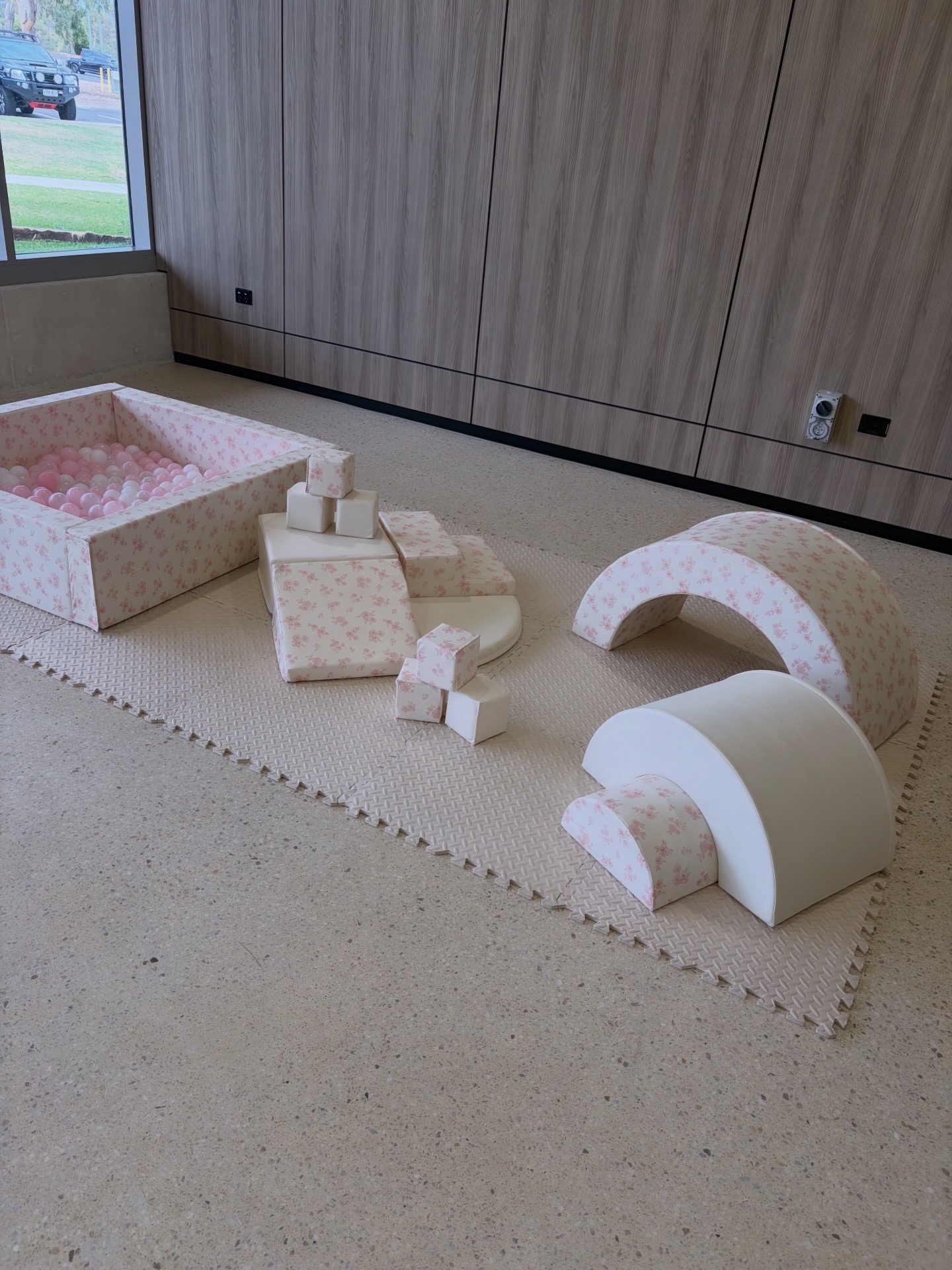 Pink floral soft play setup with ball pit, climber and arch styled indoors.