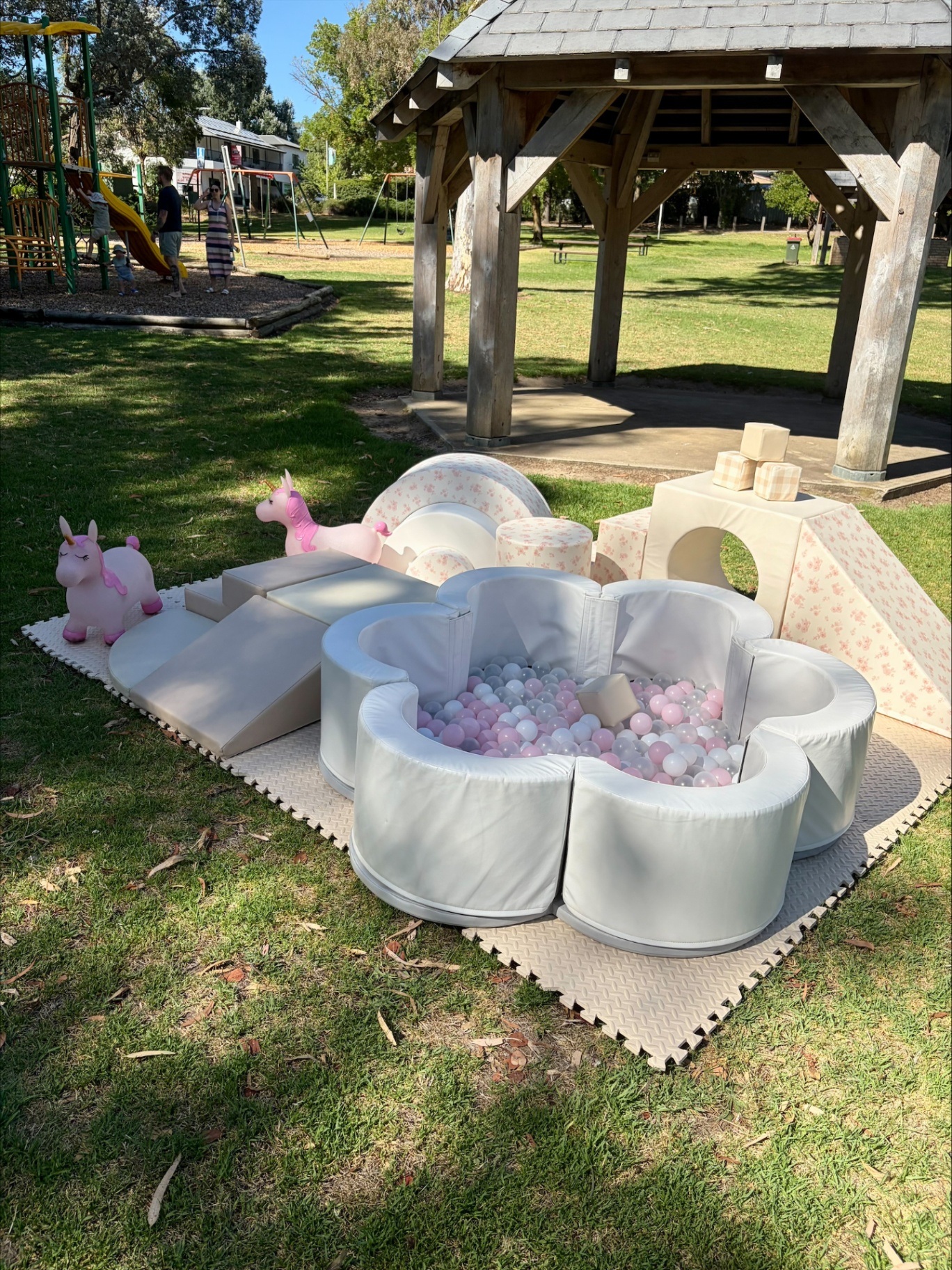 Pink and cream flower-shaped soft play ball pit set up outdoors in a Barossa park.